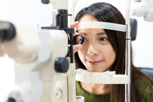 Preview: Woman cheking eye test in clinic