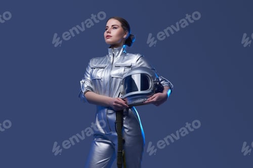 Preview: Young spacewoman in silver suit holding helmet