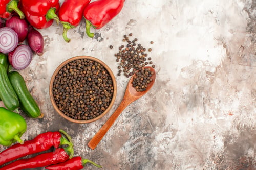 Preview: Horizontal view of black pepper various chopped and whole vegetables on mixed color background