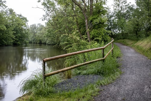 Preview: Path for walking and cycling, with wooden railings to prevent falling into the river. Landscape.