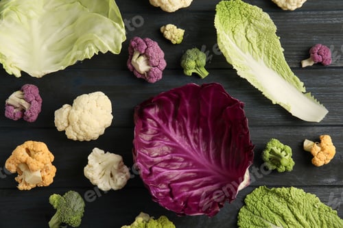 Preview: Fresh leaves of different cabbages on wooden table, top view. Healthy food