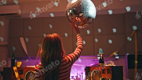 Preview: Woman touching disco ball relaxing alone in room close up. Girl holding beer
