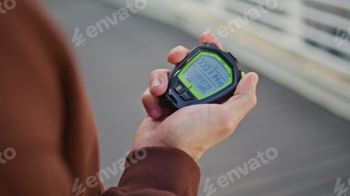 Preview: Closeup hand holding stopwatch during sport competition. Man coach timing effort