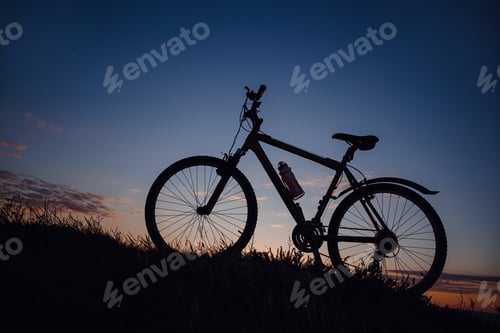 Preview: silhouette of a bicycle on the sunset sky