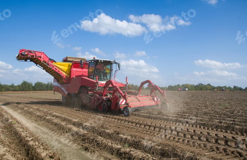 Preview: Agricultural Harvesting Machine in Field Under Blue Sky