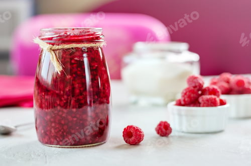 Preview: Raspberries with sugar. Homemade jam with fresh berry on the table, selective focus.