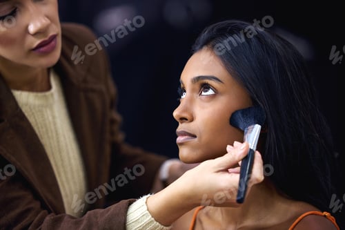 Preview: Shot of a young woman having her blush touched up during a photo shoot