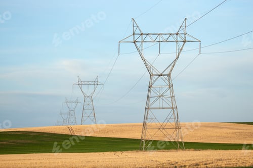 Preview: Row of high voltage pylons at a field against a cloudy sky in southeastern Wyoming