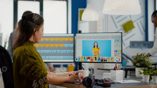 Preview: Woman retoucher looking at camera smiling working in creative media agency