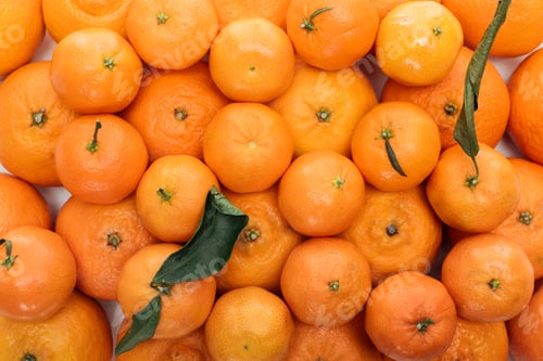 Preview: top view of whole ripe tangerines with green leaves in stack on white background