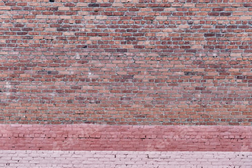 Preview: Red brick old wall with painted pink stripes at bottom