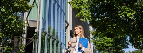 Preview: Portrait of confident saleswoman in her 30s, posing near office building on street, wearing beige