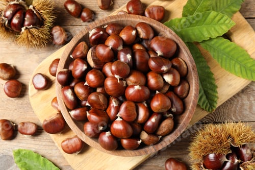 Preview: Fresh sweet edible chestnuts on wooden table, flat lay