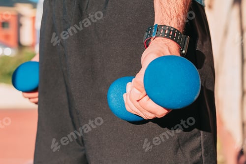 Preview: Close up shot of the hands of a sportsman holding weights