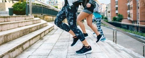 Preview: Young women friends training running up stairs in town