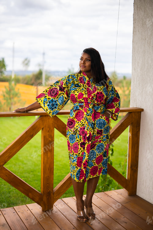 Preview: African american woman relaxing and enjoying sun while standing at terrace or balcony at sunlight at