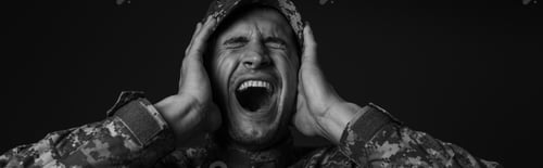 Preview: monochrome photo of stressed soldier in uniform and cap screaming while suffering from ptsd