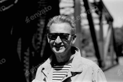 Preview: Senior man smiling wearing sunglasses in black and white analog photo