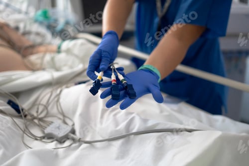 Preview: Nurse preparing ecg electrodes for patient monitoring