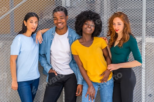 Preview: Happy multiethnic friends in the city on a gray wall, young models