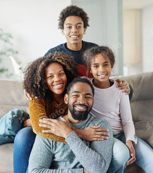 Preview: Smiling Family Portrait on Gray Couch Indoors