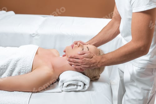 Preview: Male masseur doing face massage to woman in spa room