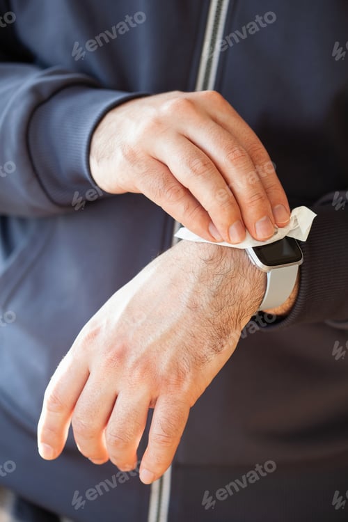 Preview: man hands disinfecting smart watch, eliminating germs coronavirus bacteria