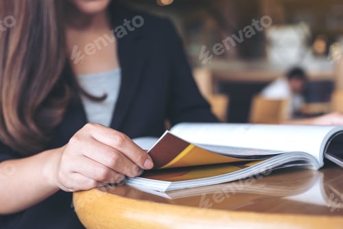 Preview: Closeup image of a business woman reading a book in modern cafe