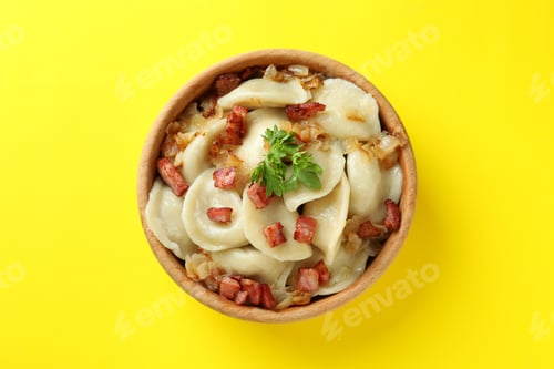Preview: Bowl of vareniki or pierogi on yellow background