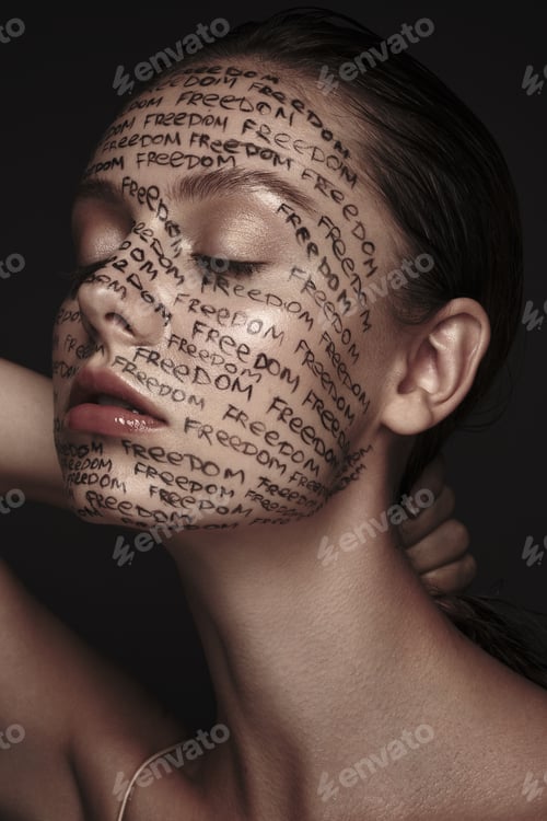 Preview: Portrait of beautiful woman with painted words on her face. Art make-up.