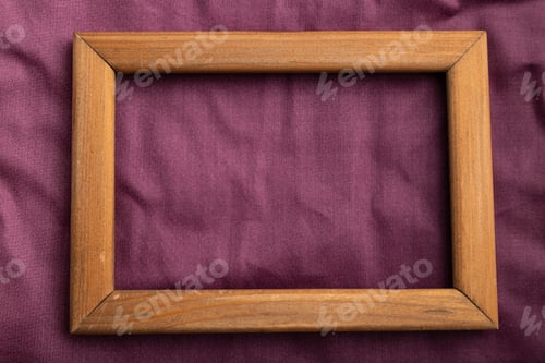 Preview: Wooden frame on smooth cotton purple tissue. Top view, natural textile background.