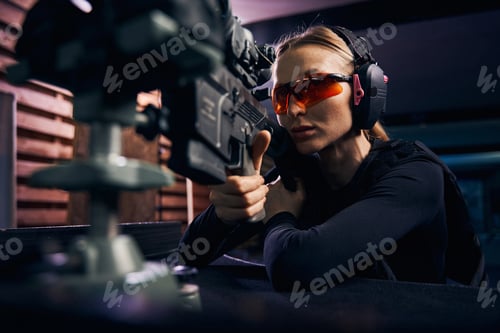 Preview: Serious woman using a telescopic sight for target shooting