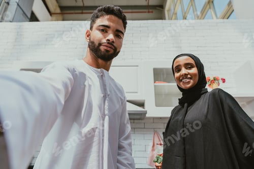 Preview: Happy middle eastern couple wearing traditiona larab clothing at home