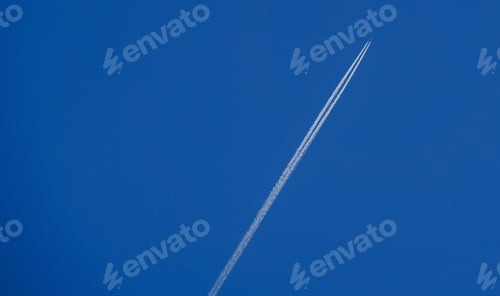 Preview: Plane flying in the blue clear sky with a white streak
