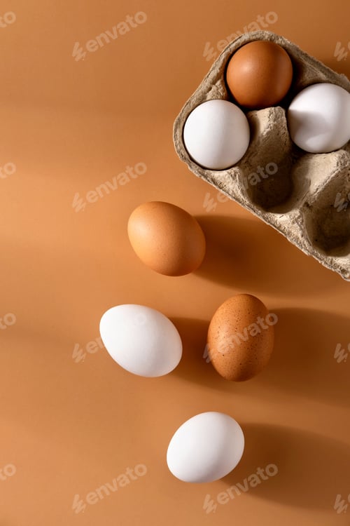 Preview: Brown and white chicken egges on beige background. Chicken eggs on the table.