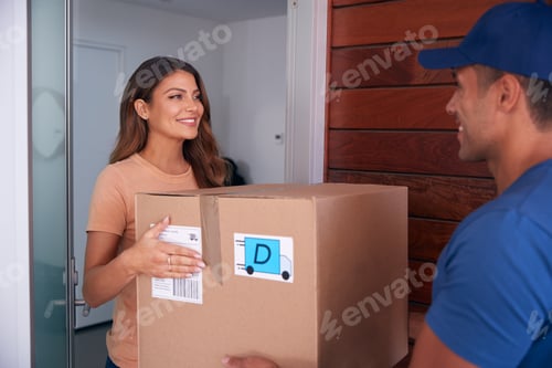 Preview: Woman Receiving Package Delivered By Courier To Home