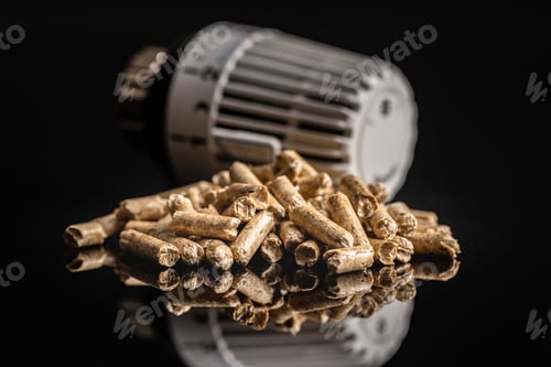 Preview: Wooden pellets and thermostatic valve head on black background.