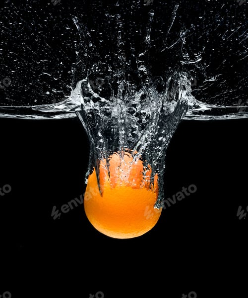Preview: close up view of fresh orange citrus fruit falling into water isolated on black