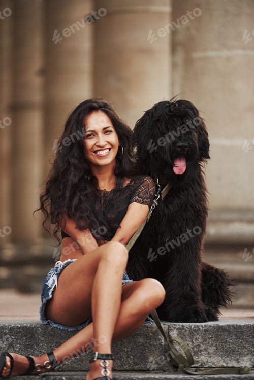 Preview: Big cute dog. Beautiful woman with curly black hair have good time in the city at daytime