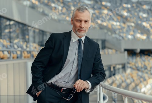 Preview: Portrait of mature businessman standing by the observation deck at stadium