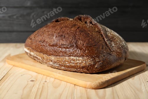 Preview: Loaf of fresh bread on light wooden table, closeup