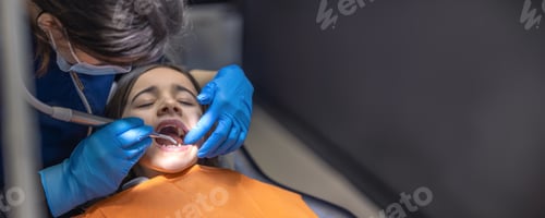 Preview: Dentist at work. Young woman dentist treating kid tooth. Dentistry concept.