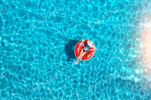 Preview: Aerial view of a young woman swimming with red swim ring