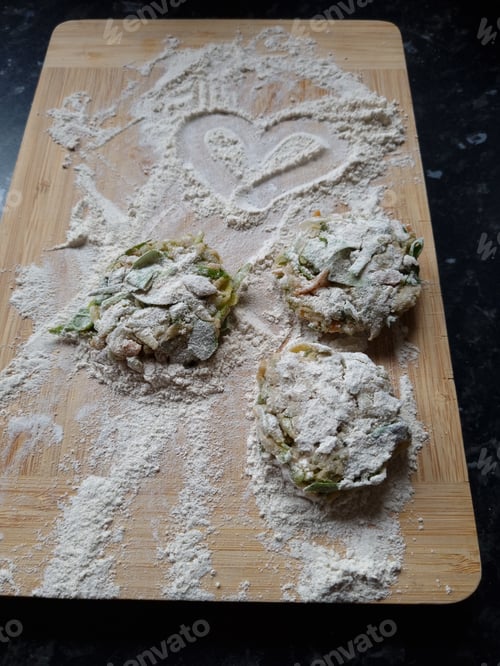 Three Vegetable Patties on a Cutting Board with Flour