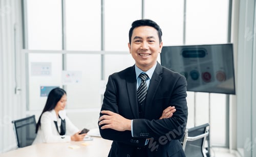 Preview: Successful asian businessman working and looking camera.