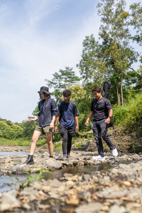 Preview: group of young asian trekking and hiking on rocky river stream