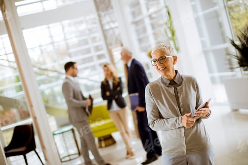 Preview: Portrait of senior businesswoman standing with digital tablet