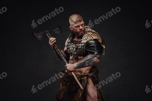 Preview: Brutal tattooed warrior wearing light armour and fur holding two-handed axe in dark studio