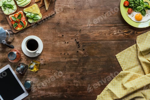 Preview: top view of cup of coffee, tablet, tablecloth and breakfast on wooden tabletop