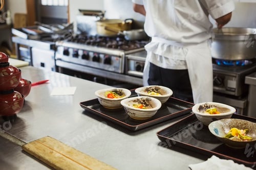 Preview: High angle view of trays with bowls of freshly prepared food on the kitchen counter of a Japanese
